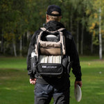 Player wearing the Latitude 64 DG Luxury E5 backpack in Sand/Black on the course